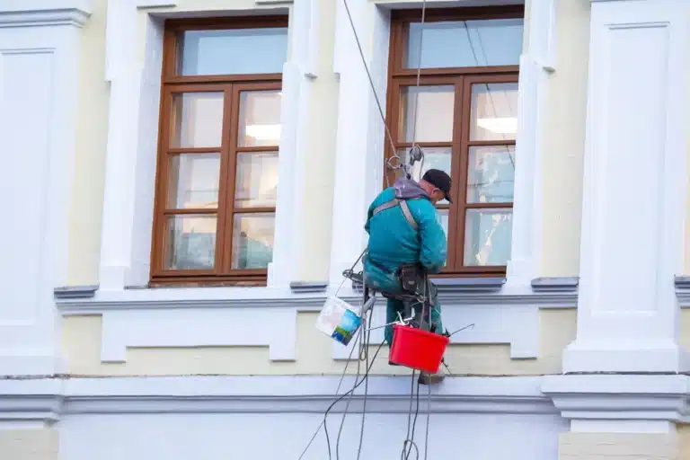 Peinture de façade sur un immeuble à Rouen réalisée par un artisan en hauteur.