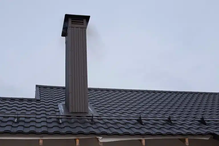 Conduit de cheminée installé sur une toiture en métal à Rouen.